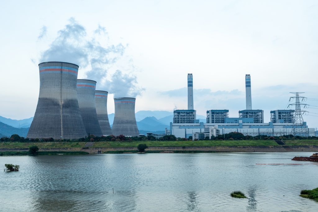 Elektrownia z chłodniami kominowymi nad zbiornikiem wodnym – infrastruktura energetyczna wykorzystująca wodę w procesach chłodzenia.
