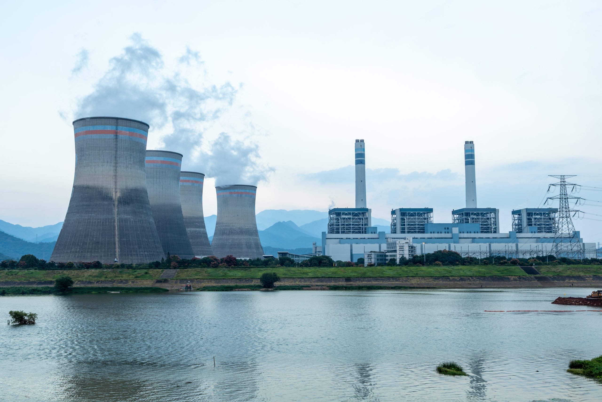 Elektrownia z chłodniami kominowymi nad zbiornikiem wodnym – infrastruktura energetyczna wykorzystująca wodę w procesach chłodzenia.